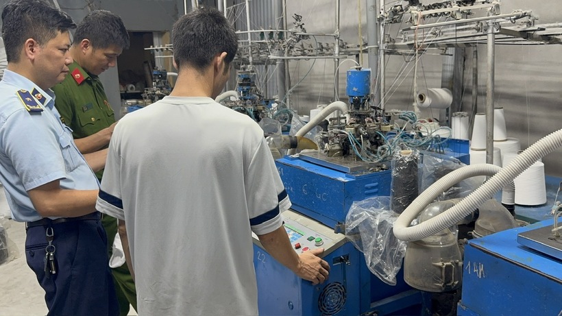 Lực lượng chức năng kiểm tra cơ sở sản xuất tất giả mạo nhãn hiệu tại thôn Phú Hữu 1, xã Phú Nghĩa.