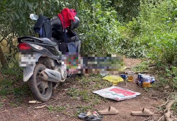 Chếc xe máy và 10 vỏ lon bia được phát hiện gần khu vực thi thể đôi nam nữ. Ảnh: Người lao động