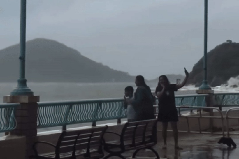 3 người bất chấp cảnh báo về siêu bão mạnh nhất thế giới năm 2025, vẫn đứng sát bờ biển chụp ảnh, làm dấy lên làn sóng tức giận trong cư dân mạng. Ảnh: Dimsum Daily