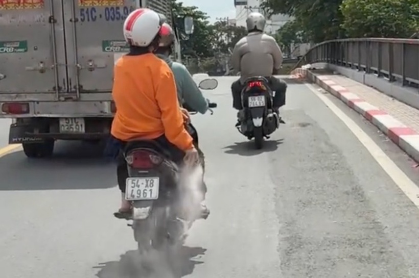 Người phụ nữ rải bột lạ xuống đường. Ảnh: VietNamNet.