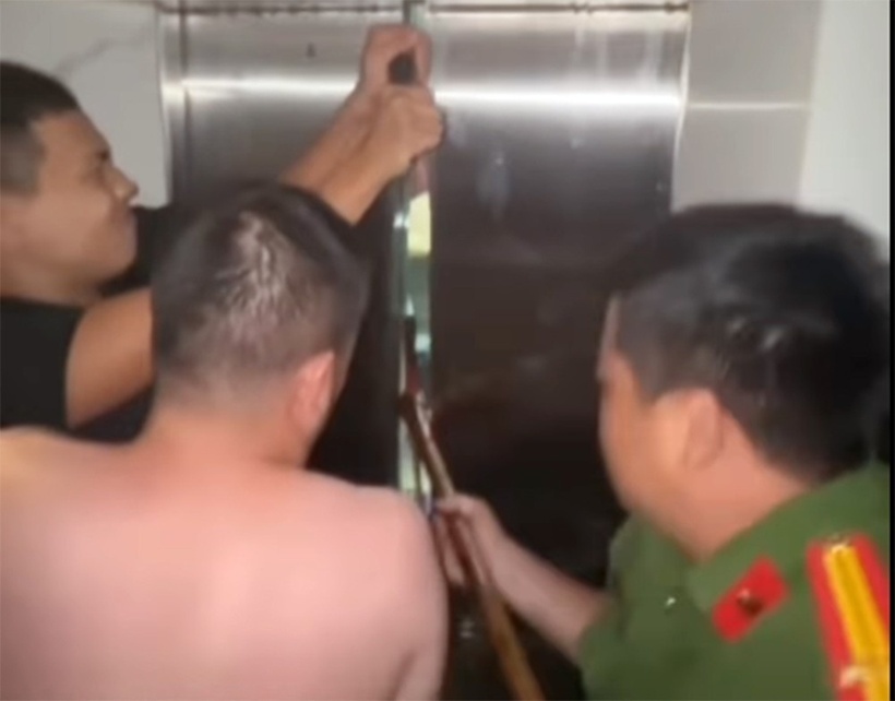 Lực lượng chức năng sử dụng thiết bị chuyên dụng mở cửa thang máy để giải cứu nạn nhân. Ảnh: Báo Tiền phong.