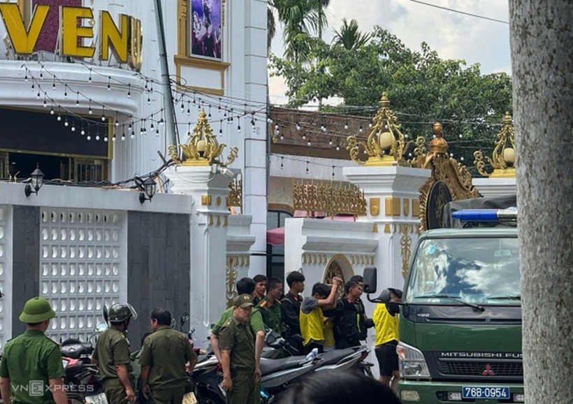 Công an đột kích quán karaoke, đưa nhiều người ra ngoài. Ảnh: VnExpress