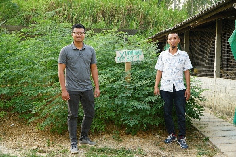 Anh Hà Minh Nguyện (trái) và anh Lại Thành Biên bên vườn thảo dược của trang trại. Ảnh: Tiền phong