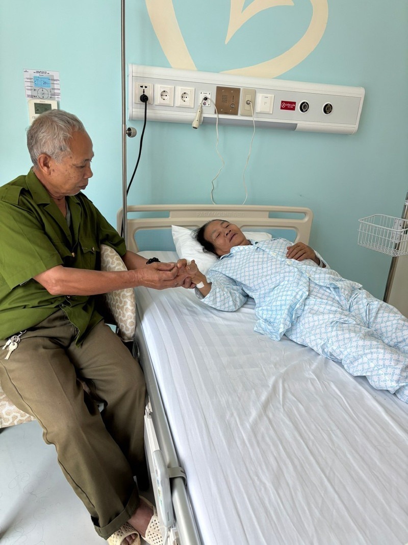 Ông Canh ngồi bên giường bệnh của bà Ất. Ảnh: VietNamnet
