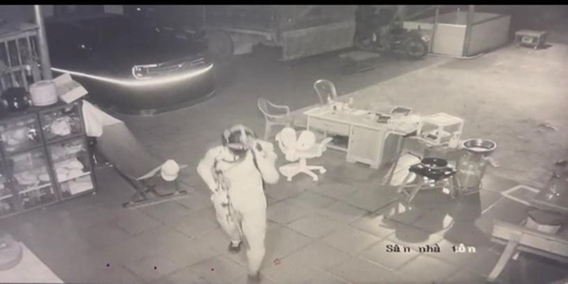 Người đàn ông đội mũ bảo hiểm trùm kín mặt và đeo khẩu trang xuất hiện trong sân nhà nạn nhân. Ảnh: Báo Người lao động.
