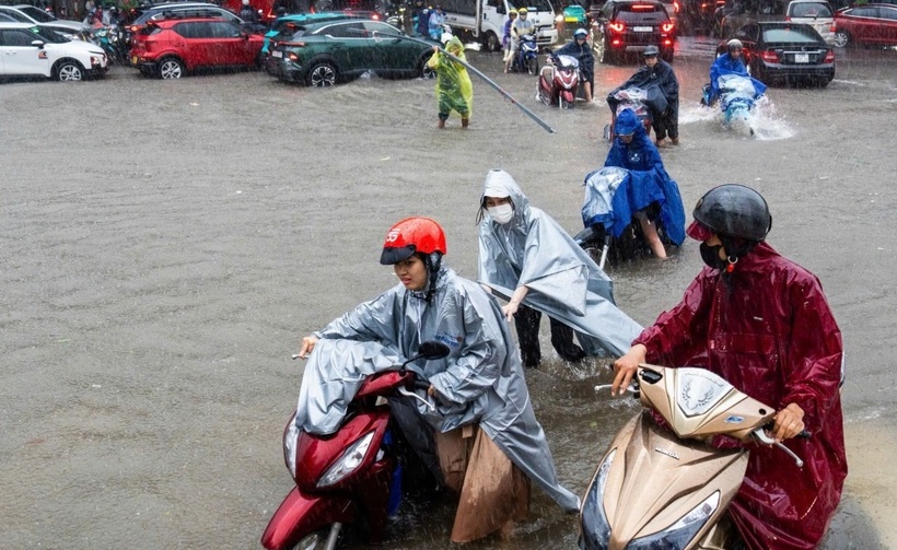 Người dân dắt xe đi qua điểm ngập đoạn bến xe Mỹ Đình, sáng 30/9. (Ảnh: VnExpress)