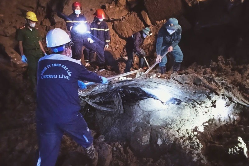 Lực lượng cứu hộ xuyên đêm tìm kiếm nạn nhân vùi dưới lớp đất đá. (Ảnh: Cơ quan công an)