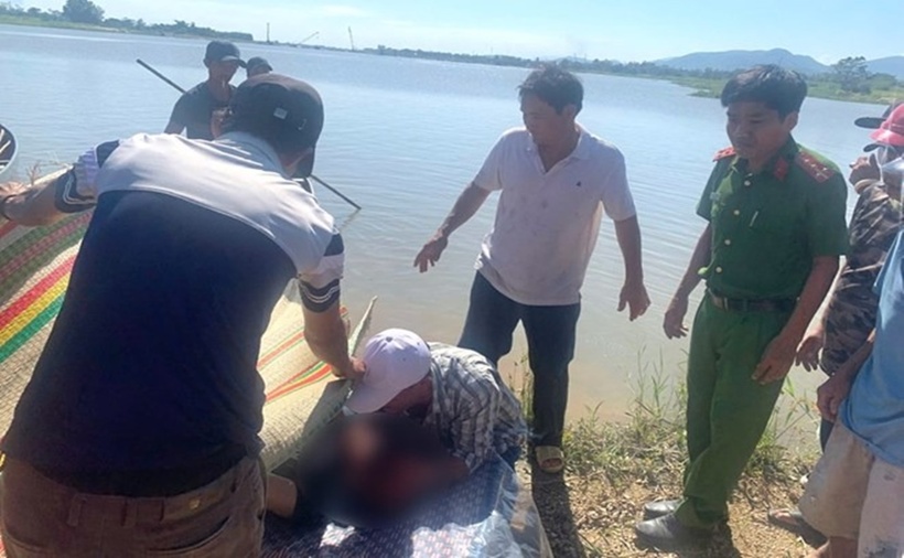 Lực lượng chức năng và người dân Gia Lai đưa thi thể chị Ng. lên bờ. (Ảnh: Lao động)