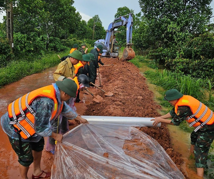 Cán bộ, chiến sĩ Ban Chỉ huy phòng thủ khu vực 3 - Tân Yên và dân quân gia cố đê chống tràn. (Ảnh: VietnamNet)