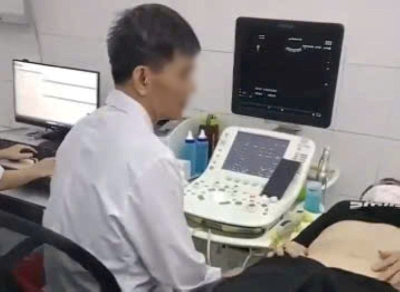 Hình ảnh bác sĩ được cho là vừa siêu âm vừa xem điện thoại. Ảnh: VietNamNet