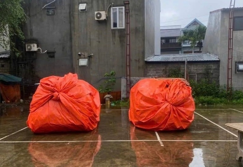 Hai chiếc ô tô của gia đình chị Nguyệt Anh được bọc bạt kín mít để tránh nước vào xe. (Ảnh: Tiền phong)