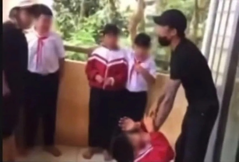 Người đàn ông mặc áo đen túm cổ áo nam học sinh mặc áo đỏ, liên tục doạ. Ảnh: PLO.