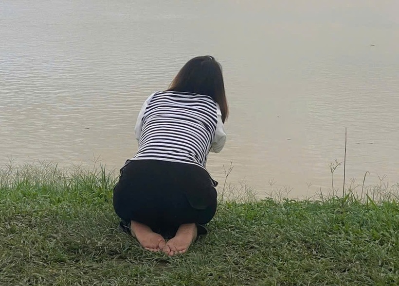 Hình ảnh người mẹ quỳ gối bên bờ sông, gọi tên hai con gái khiến ai nấy xót xa. Ảnh: VietNamnet