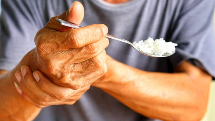 Người cao tuổi bị Parkinson gây run tay khi cầm nắm đồ vật
