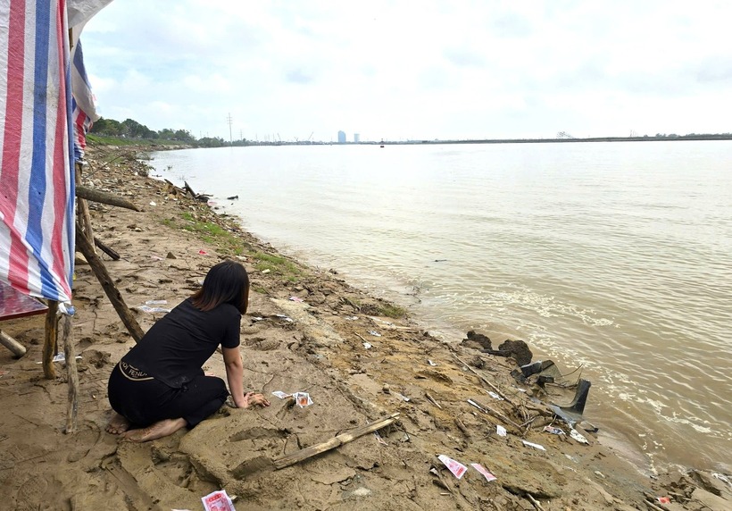 Người mẹ gục ngã bên bờ sông Lam trước nỗi đau quá lớn. Ảnh: Dân Việt