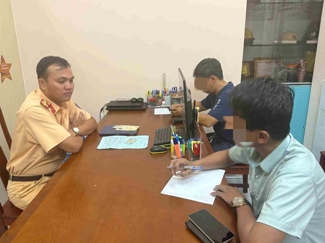 CSGT An Sương mời 2 tài xế lên làm việc. Ảnh: Lao động