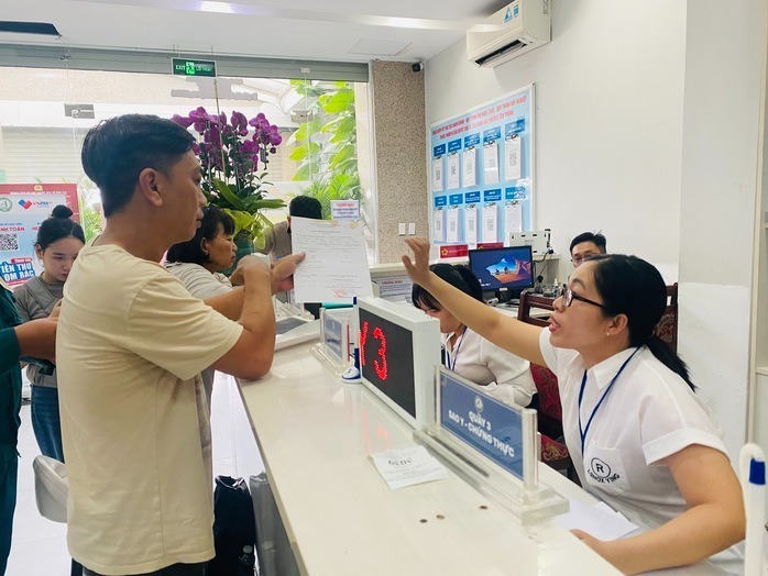 Cán bộ, công chức phường Bến Thành, TP.HCM hướng dẫn thủ tục hành chính cho người dân. Ảnh: Người lao động
