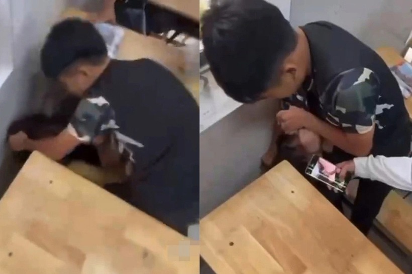 Nam sinh dí mặt bạn nữ xuống ghế, đấm vào đầu, gọi bạn đến quay rõ mặt nạn nhân. (Ảnh: Dân trí)