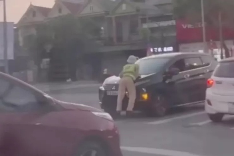 Tài xế không chấp hành hiệu lệnh, CSGT bị hất lên nắp capo. Ảnh: PLO.