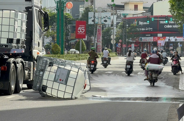 Người đi đường bịt mũi vì mùi hôi khó chịu bốc ra từ thùng chất lỏng rơi xuống đường. (Ảnh: Tuổi trẻ)