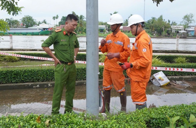 Cảnh sát và điện lực kiểm tra hiện trường trụ đèn bị rò rỉ điện, chiều 24/10. Ảnh: VnExpress
