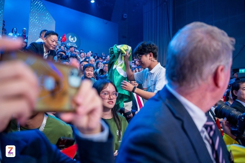 Bảo Khánh chạy xuống khu vực khán giả, nhận lá cờ màu xanh của khối chuyên Sinh, Trường THPT chuyên Hà Nội - Amsterdam.