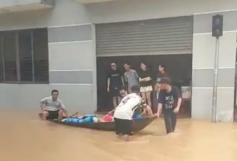 Người dân lội nước đưa các nạn nhân ra khỏi vùng ngập. Ảnh: Pháp luật TP.HCM