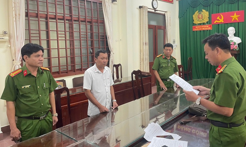 Cơ quan CSĐT tống đạt quyết định khởi tố bị can, lệnh bắt tạm giam ông Trung (áo trắng). Ảnh: Công an tỉnh Vĩnh Long/ Vietnamnet