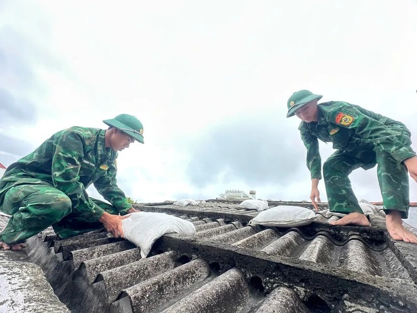 Bộ đội giúp người dân chằng chống nhà cửa. Ảnh: PLO