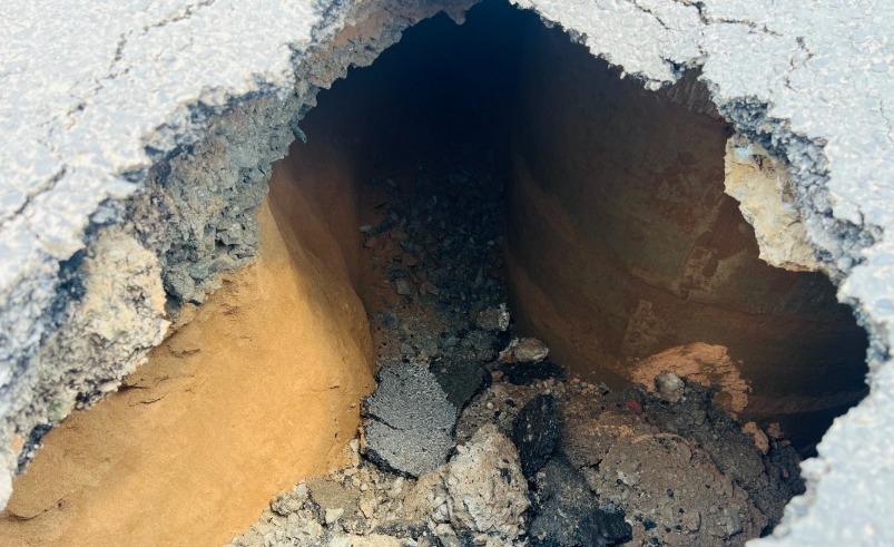 Nhựa đường và đất bị sụt tạo hố sâu khoảng 2,5m. (Ảnh: Dân trí)