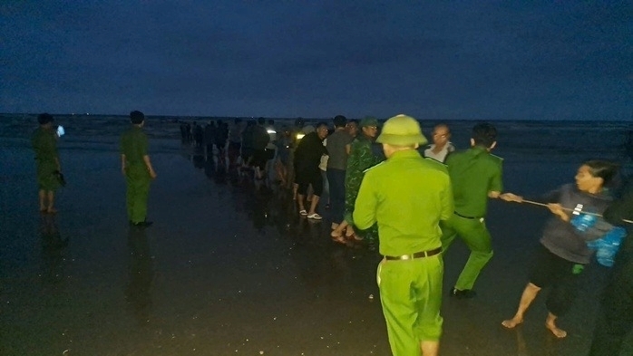 Lực lượng chức năng cùng người dân địa phương tìm kiếm người mất tích và trục vớt phương tiện gặp nạn. Ảnh: Người lao động