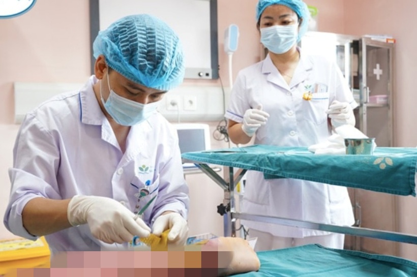 Bác sĩ  chăm sóc vết thương ở vùng chân cho bệnh nhi. Ảnh: Vnexpress.
