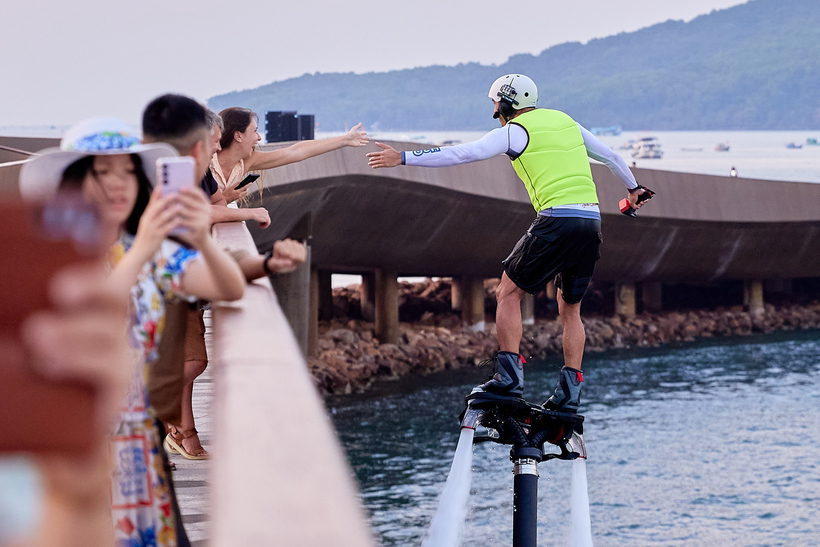 Du khách thích thú tương tác với vận động viên biểu diễn tại Cầu Hôn