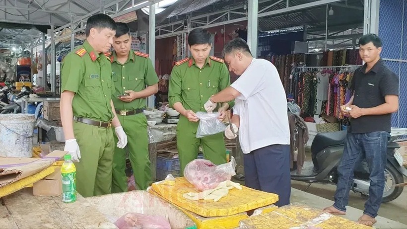 Lực lượng công an lấy mẫu thịt heo của người bán tại chợ đi kiểm tra. Ảnh: Pháp luật TP.HCM