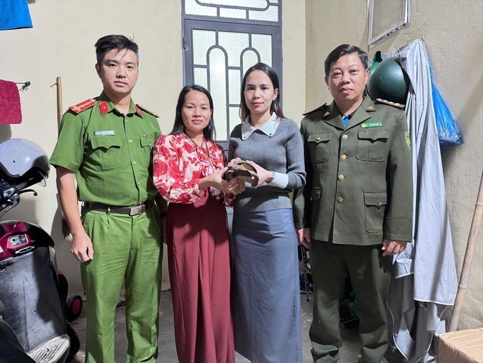 Chị Diệu Ái (áo xám) bàn giao con rùa quý để thả về tự nhiên. Ảnh: Người lao động
