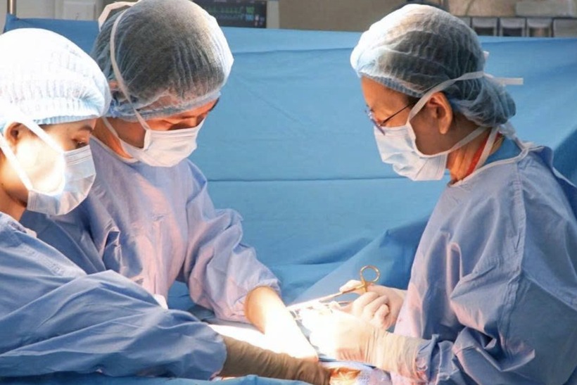Các bác sĩ tiến hành phẫu thuật mổ bắt con cho bệnh nhân. Ảnh: Dân Trí.