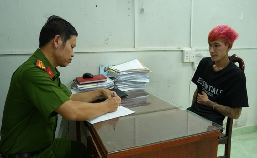Công an lấy lời khai đối tượng cướp tài sản nhuộm tóc màu hồng, xăm trổ kín người. (Ảnh: Người lao động)