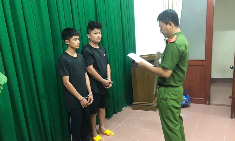 Điều tra viên đọc lệnh khởi tố vụ án, khởi tố bị can, lệnh bắt bị can để tạm giam đối với Châu Tấn Phát và Võ Văn Giàu. (Ảnh: Công an tỉnh Vĩnh Long)