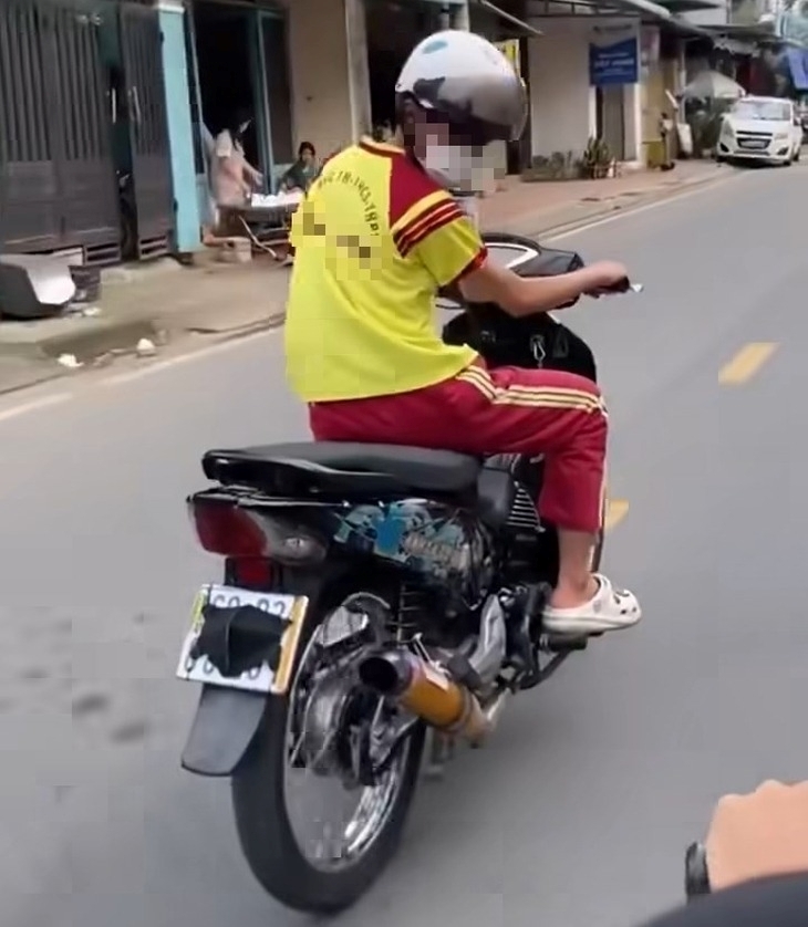 Nam học sinh chạy xe máy "độ" pô với âm thanh lớn, dùng khẩu trang che biển số ở TP.HCM. Ảnh: Tuổi trẻ