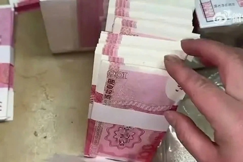 Người đàn ông dùng một xấp tiền giả để lừa đảo phụ nữ. Ảnh: SCMP