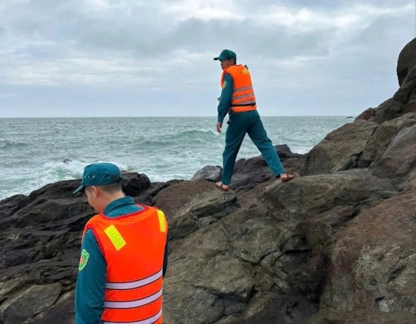 Lực lượng chức năng tìm kiếm anh C.N.K tại khu vực mõm đá ở vùng biển xã Vạn Tường. (Ảnh: Pháp luật TP.HCM)