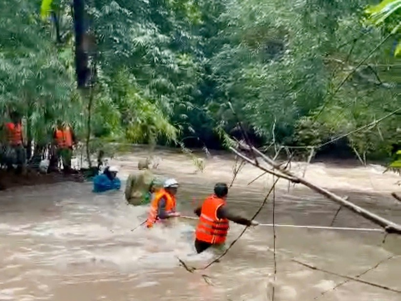 Công nhân đo đạc bị nước lũ cô lập được lực lượng chức năng giải cứu. (Ảnh: Dân trí)
