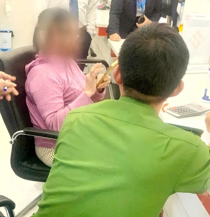 Công an phường Long Hương phối hợp với ngân hàng ngăn chặn một phụ nữ chuẩn bị chuyển tiền cho các đối tượng lừa đảo. Ảnh: SGGP
