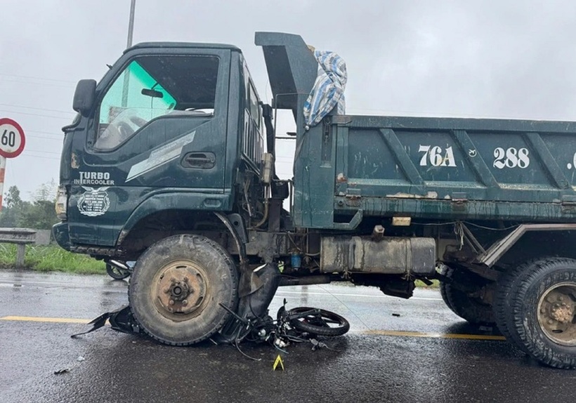 Xe máy bị kéo lê và nằm dưới gầm xe tải, hư hỏng nặng. Ảnh: PLO