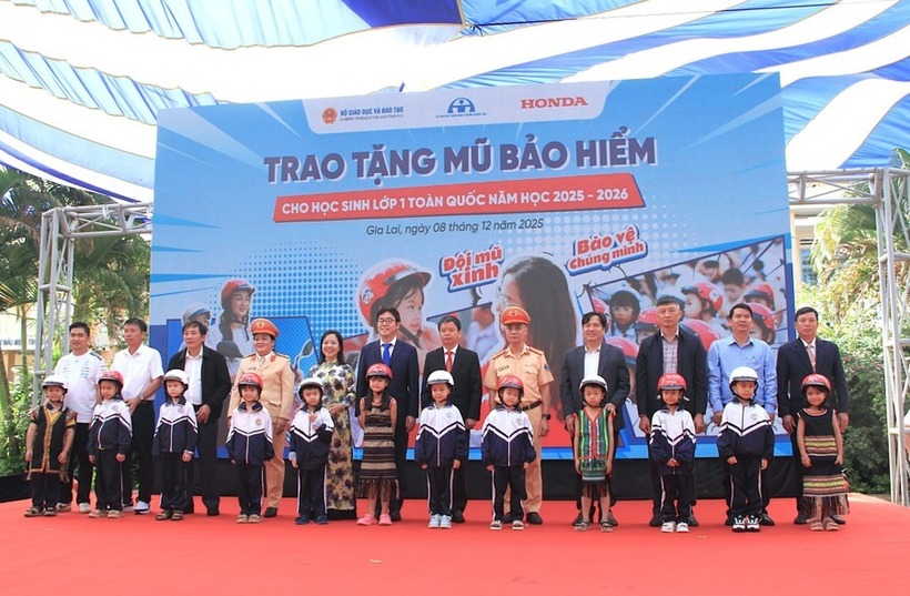 Các đại biểu trao tặng mũ bảo hiểm cho các em học sinh lớp 1 trường Tiểu học Lê Quý Đôn