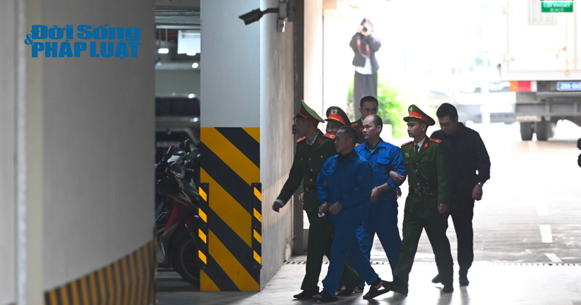 Các bị cáo được cảnh sát dẫn giải đến phiên tòa.