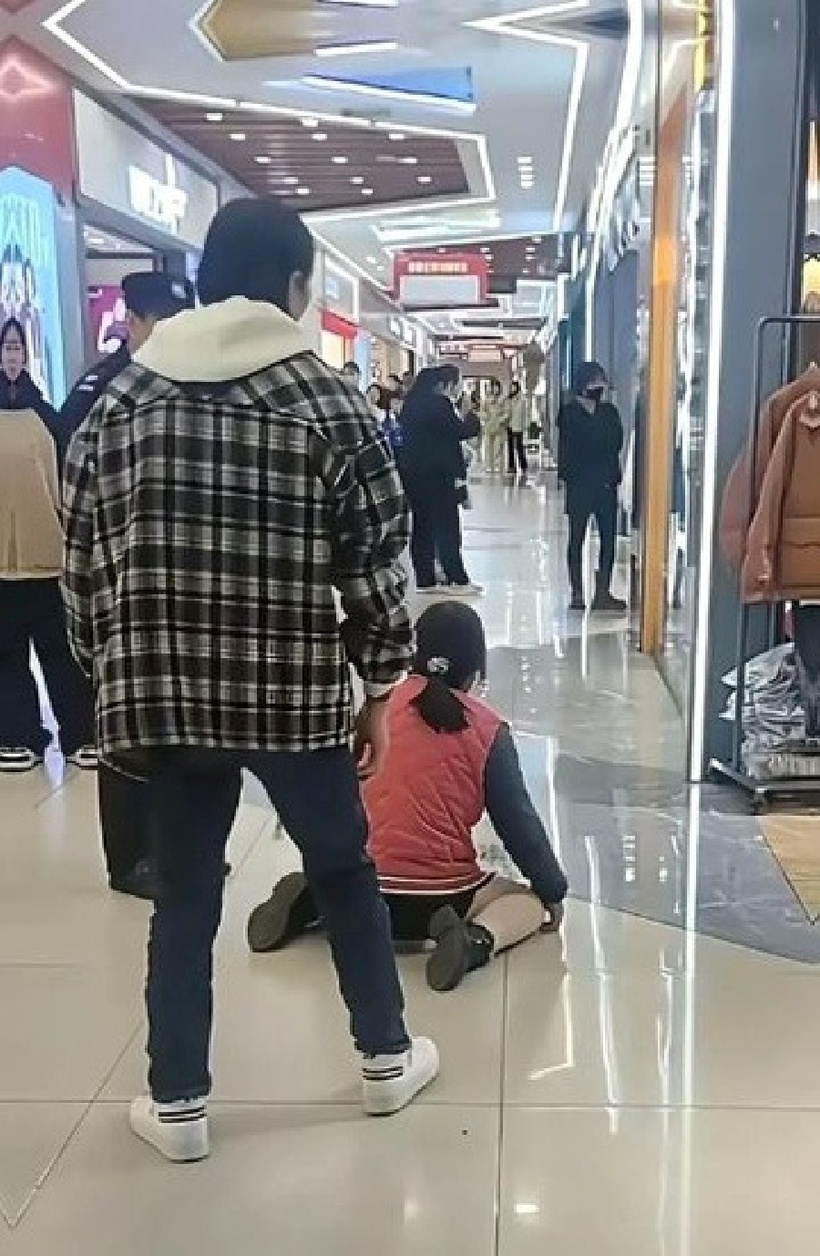 Sau cuộc cãi vã, người đàn ông bỏ đi, để mặc người vợ vẫn quỳ giữa trung tâm thương mại. Ảnh: Stheadline.