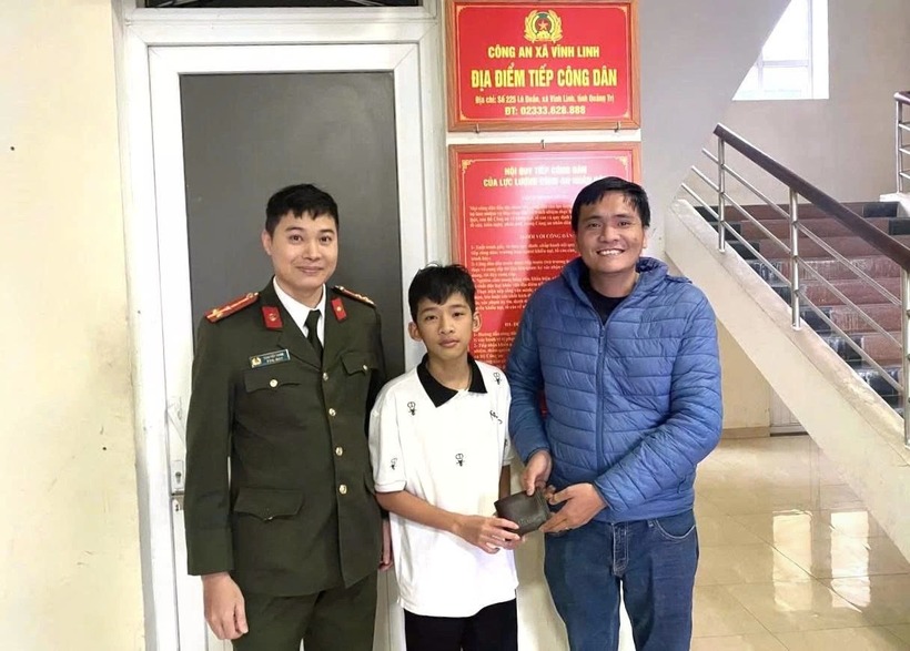 Em Đức trả lại ví tiền cho người đánh rơi trước sự chứng kiến của Công an xã Vĩnh Linh. (Ảnh: Tiền phong)