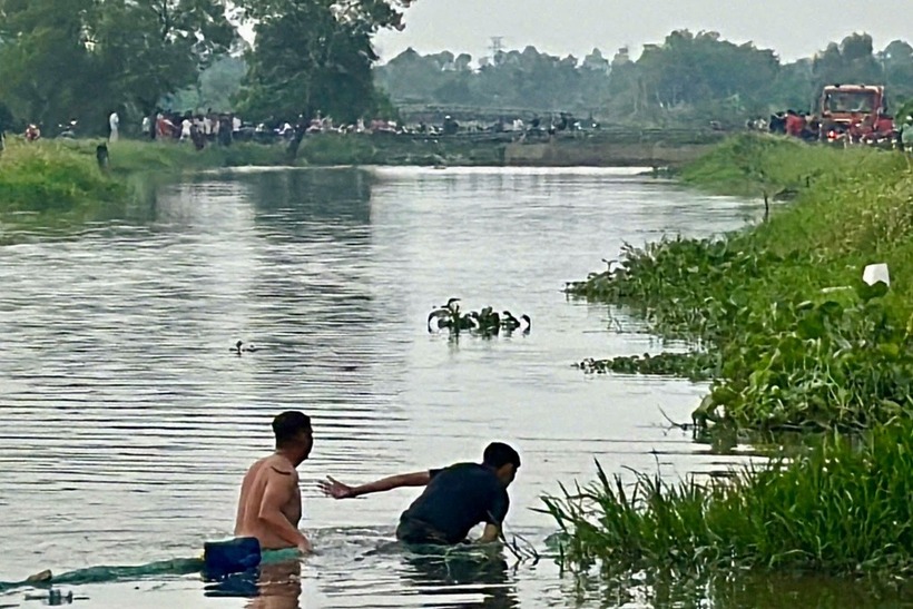 Người dân cùng lực lượng chức năng tìm kiếm thi thể 2 thiếu niên đuối nước dưới kênh ở xã Đông Thạnh (Ảnh: Dân Trí)