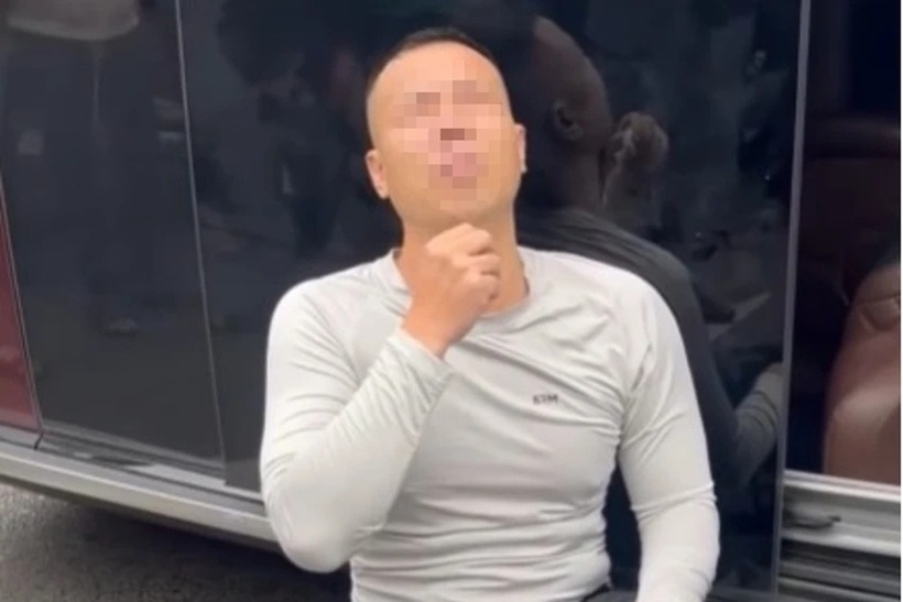 Tài xế ngồi trên chiếc xô nhựa lật úp cạnh xe Hyundai Santa Fe với biểu hiện lạ. Ảnh: PLO.